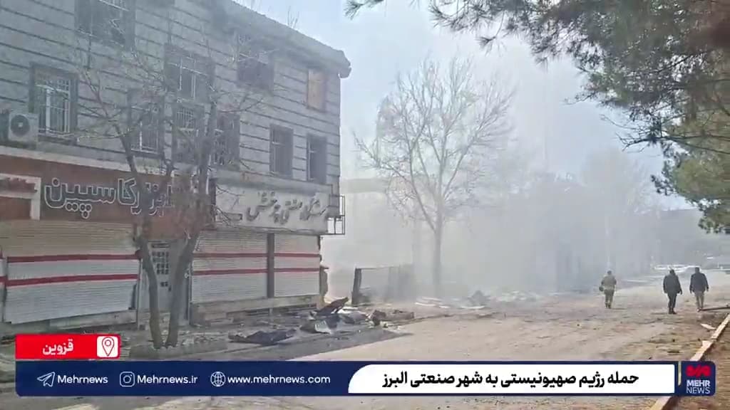 Dust hangs in the air from a recent missile attack, with visible destruction throughout the scene